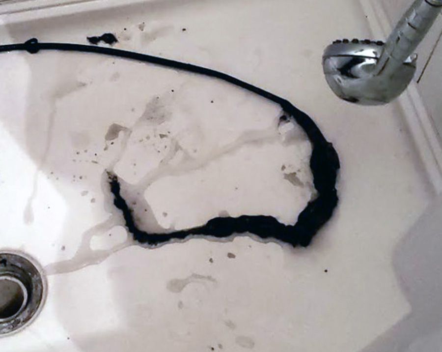 Debris removed from clogged residential drain during cleaning