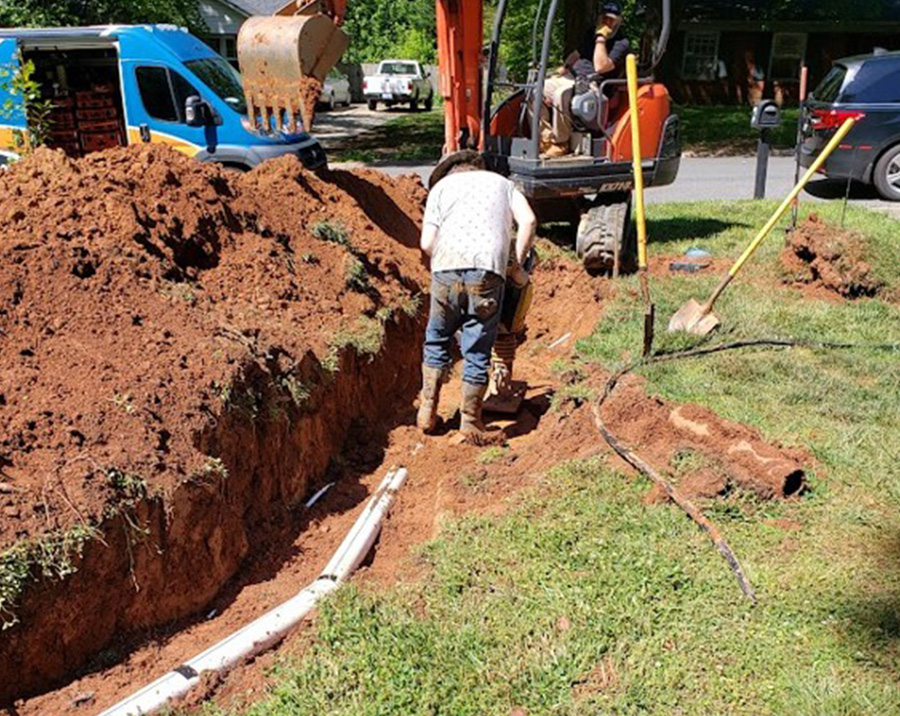 Sewer line repair trench with exposed underground pipe by Pathmaker Plumbing in Charlotte, NC.