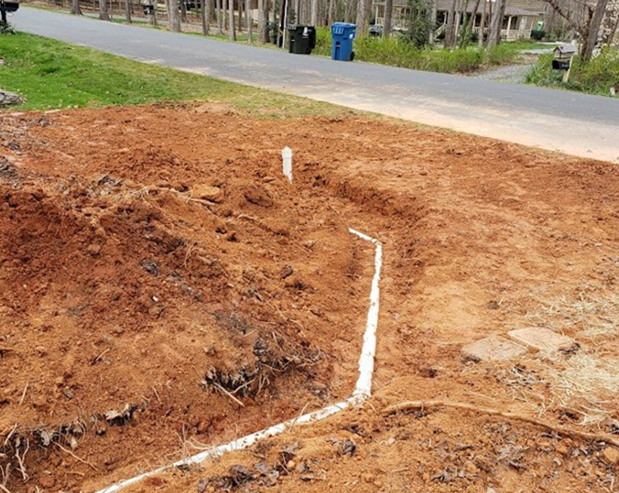 Sewer line repair trench with exposed underground pipe by Pathmaker Plumbing in Charlotte, NC.